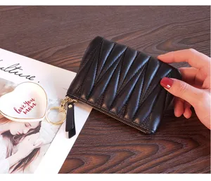 Detailed view of a compact black quilted coin purse with zipper closure and stylish hand feel.
