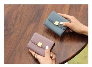 Detalles del mini tarjetero monedero de mujer en azul y rosa con cierre cuadrado dorado.