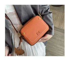 Genuine leather orange crossbody camera bag for women, stylish square shoulder bag.