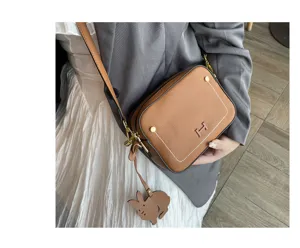 Genuine leather crossbody shoulder bag for women, stylish brown camera bag with chic rabbit charm.