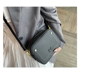 Black genuine leather camera crossbody bag for women with elegant gold hardware and H clasp.