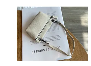 Minimalist genuine leather coin purse with zipper closure and wrist strap for daily use.
