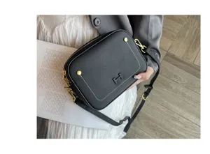 Black leather camera bag with gold hardware and stylish H logo accent for daily commuting.