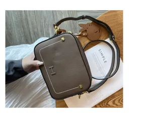 Brown leather camera bag for women, stylish square shoulder bag with metal H logo.