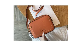 Orange genuine leather shoulder camera bag with stylish H logo and metal hardware for daily use