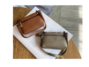 Detail view of genuine leather mini coin purse with zipper closure and wrist strap.