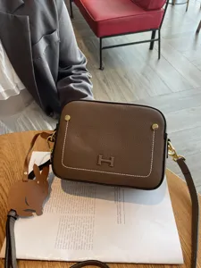 Genuine leather women's shoulder camera bag featuring stylish H hardware and cute rabbit charm.
