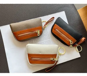 Genuine leather mini coin purse with zipper, key ring, and contrast color design for women.