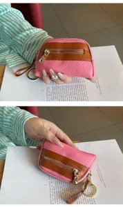 Detailed view of mini leather coin purse with zipper pocket and metal keychain ring.