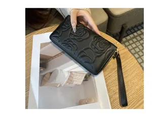Detailed view of the black leather long wallet with elegant embossed camellia pattern.