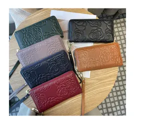 Detailed view of women's long genuine leather zipper wallet with elegant floral embossed design.
