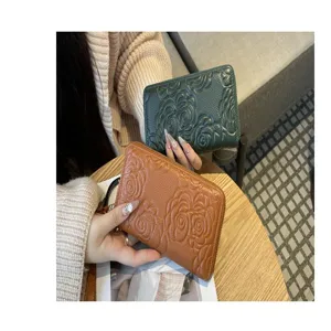 Detailed shot of genuine leather long zipper wallet with embossed floral pattern.