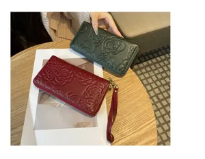 Detailed view of women's genuine leather long wallet featuring elegant embossed camellia pattern.