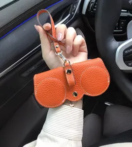 Tragbares orangefarbenes Auto-Sonnenbrillenetui aus Leder mit Schlaufe Detailansicht.