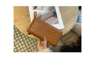 Elegant genuine leather long wallet for women with stylish camellia embossed zip design.