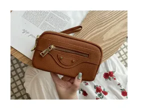 Leather motorcycle clutch bag detail view featuring front zipper pocket and metal stud hardware.