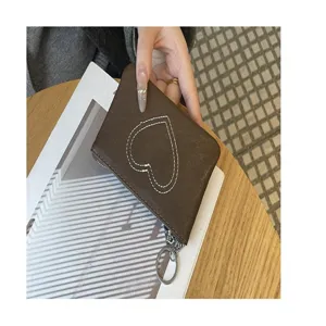 Brown leather coin purse with heart stitch, compact card holder with zipper and keychain.