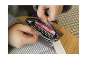 Genuine leather coin purse detail shot, black zipper card holder showing interior capacity.