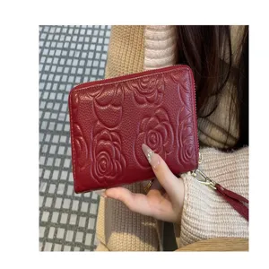 Red genuine leather long wallet with camellia embossed pattern, single zip closure detail.