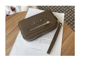 Brown genuine leather motorcycle clutch bag featuring metal studs and front zipper pocket.