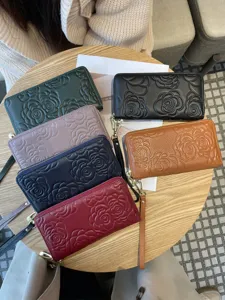 Women's genuine leather long zipper wallet with elegant embossed camellia flower design.