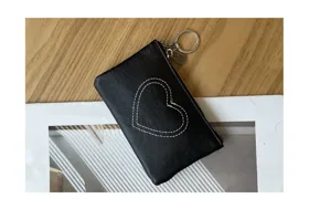 Black leather coin purse detail view showing heart stitch design and metal keychain ring.