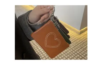Detail view of multi-layer vintage leather coin purse with cute heart stitching and keyring.