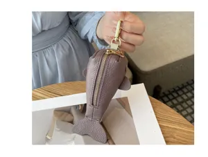 Gros plan sur le porte-clés en cuir véritable en forme de baleine avec des finitions dorées.