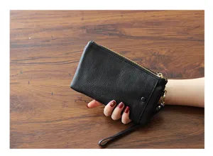Detail view of the black genuine leather women clutch wallet with wrist strap and zipper.
