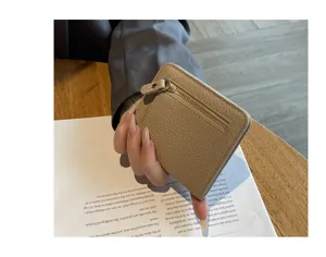 Minimalist leather short wallet for women, compact card holder with zipper pocket detail.