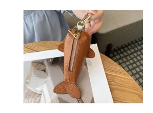 Gros plan détaillé du porte-monnaie en cuir véritable en forme de poisson avec zip.