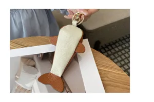 Détail de porte-clés baleine en cuir véritable avec texture de vaches et joli pendentif.