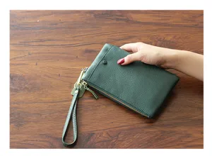 Detail view of a stylish green cowhide women clutch bag, premium leather wristlet phone pouch.