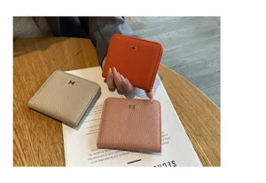 Compact genuine leather women wallet with metal H buckle, stylish short card holder purse.