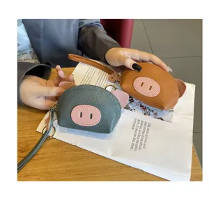 Detail shot of cute mini pig leather coin purse with wrist strap and key ring, grey and tan.