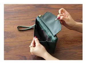 Green leather clutch bag interior detail, showing convenient snap button and large space.