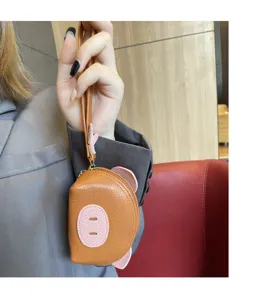 Cute pig shaped leather coin purse detail view with wrist strap, compact mini wallet pouch.