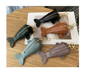 Détail en gros plan du porte-monnaie porte-clés poisson en cuir avec une texture et fermeture.