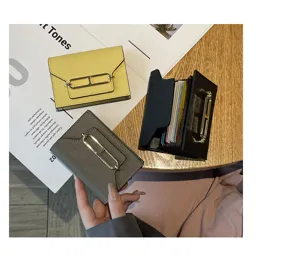 Detailed shot of leather multi-card holder with metal clasp, showcasing fine texture and design.