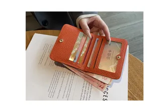 Close-up of compact genuine leather card holder wallet with multiple card slots and clear ID window.