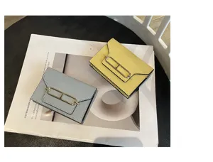 Close-up view of elegant leather card wallets with metallic H-clasp detail in a stylish setting.