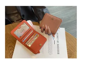 Genuine leather women's short wallet, compact bi-fold card holder with chic metal clasp design.