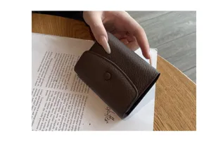 Vue détaillée d'un porte-cartes accordéon compact en cuir marron foncé avec bouton-pression.