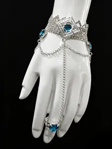 Close-up detail of silver rhinestone slave bracelet with blue crystal heart ring, fashion accessory.