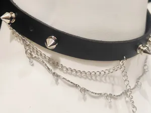 Punk style black leather choker necklace with metal studs and layered silver chains detail