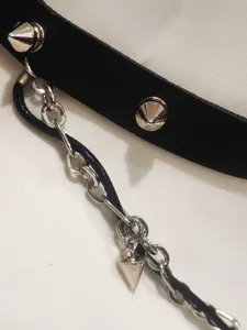 Close-up view of punk gothic PU leather choker necklace with metal cone studs and chain detail.