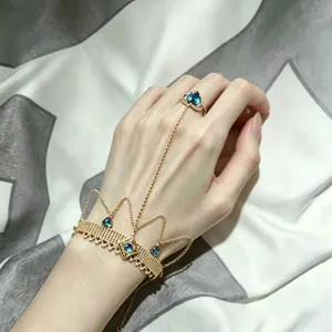 Exquisite gold tone crown hand chain bracelet with blue crystal ring for women main product view.