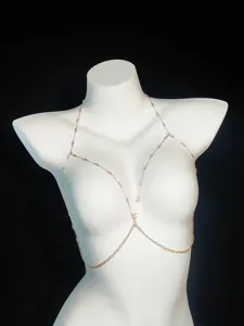 Detailed close-up view of a delicate gold-toned body chain with sparkling pink crystal beads.