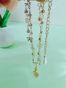 Gold multi-layer anklet set featuring rhinestones, bows, pearls, and a stylish snake pendant.