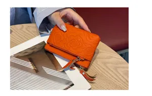 Orange genuine leather coin purse with classic floral embossing, compact card holder.